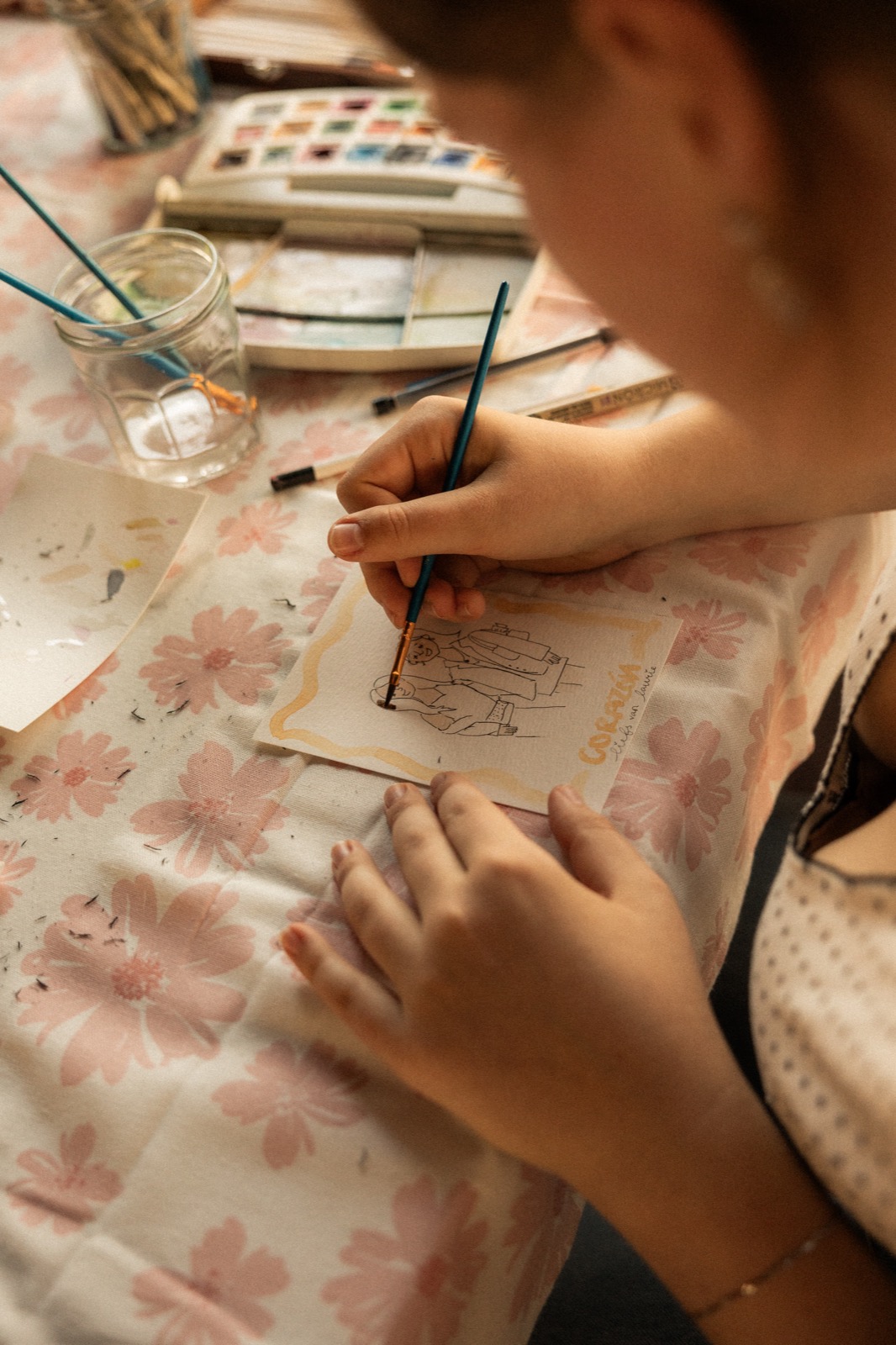 An artist painting a personal keepsake for a Corazón guest
