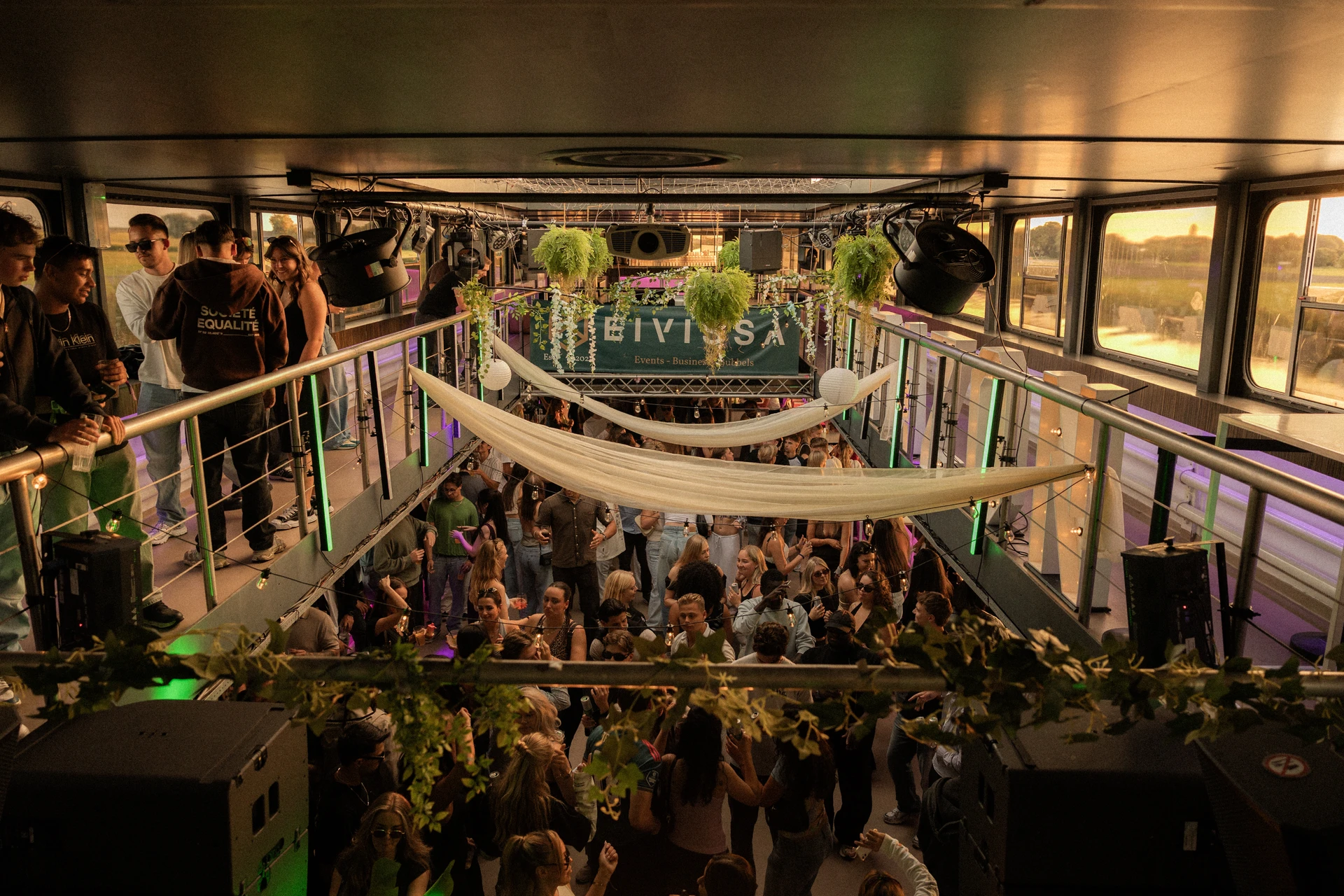 Guests filling the warm, layered interior of the Corazón Sunset Cruise venue