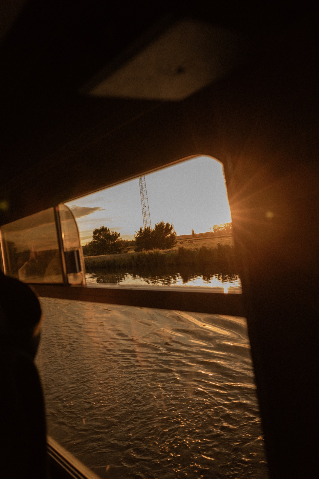Golden sunlight across the water through a boat window
